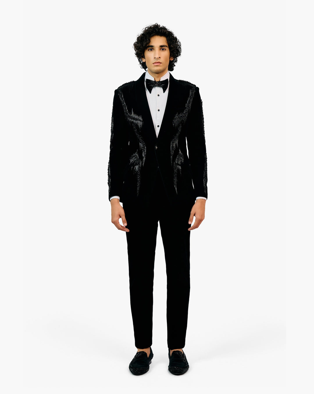 Man wearing a black tuxedo with a white shirt and black bow tie by Gaurav Gupta
