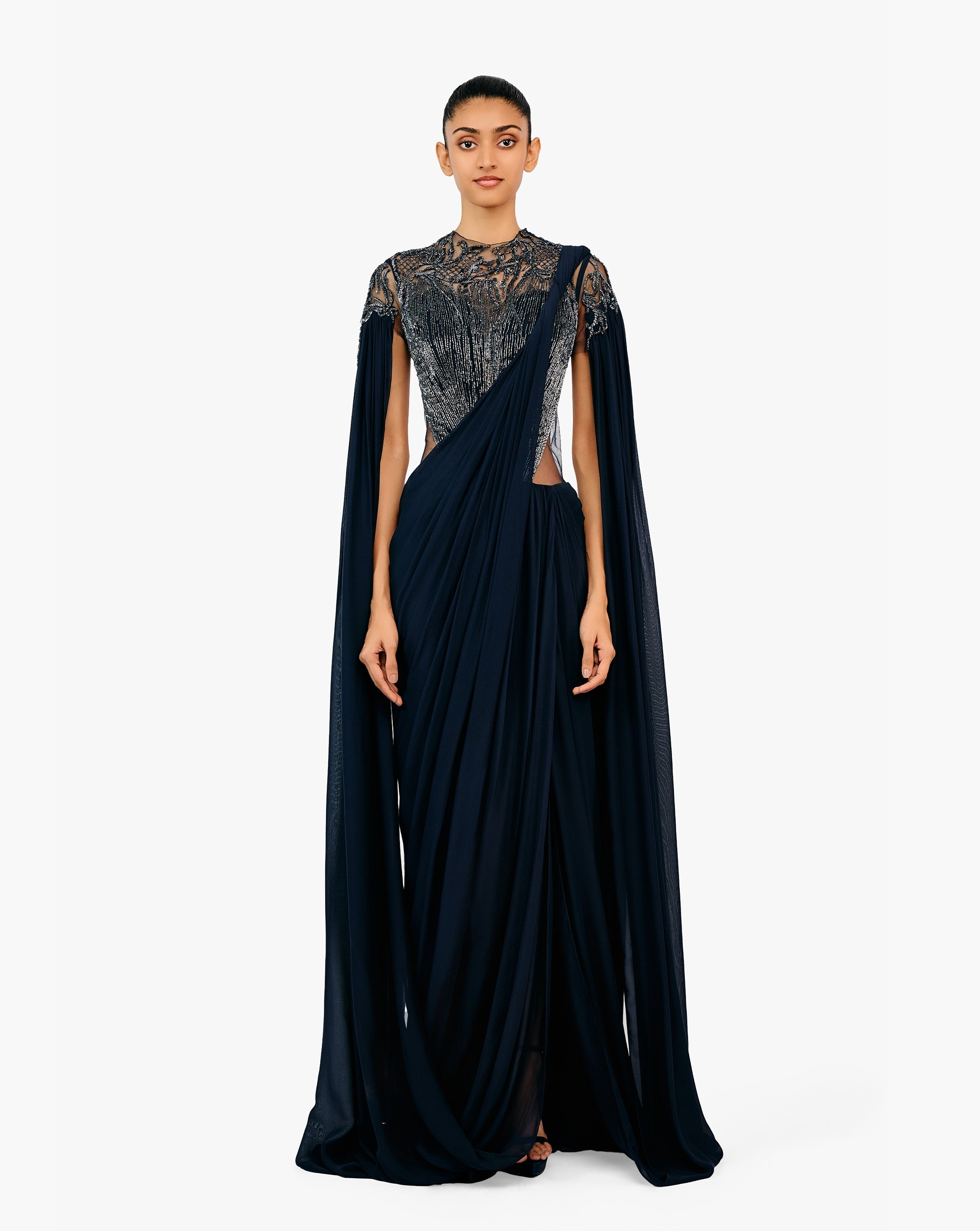 Woman wearing a black embellished draped gown by Gaurav Gupta.