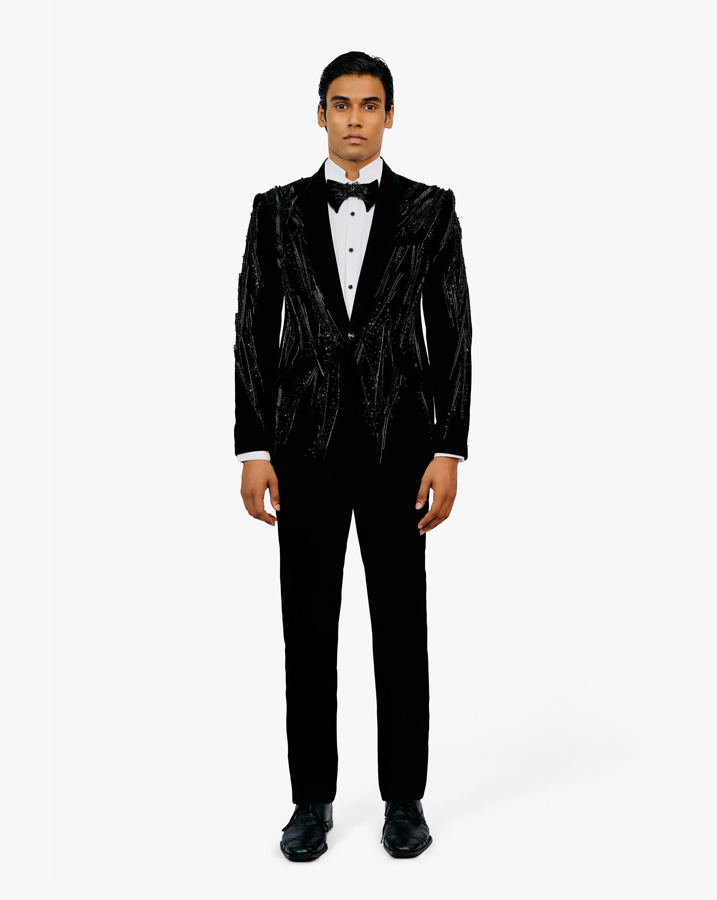 Man wearing a black embroidered tuxedo with a white shirt and bow tie by Gaurav Gupta
