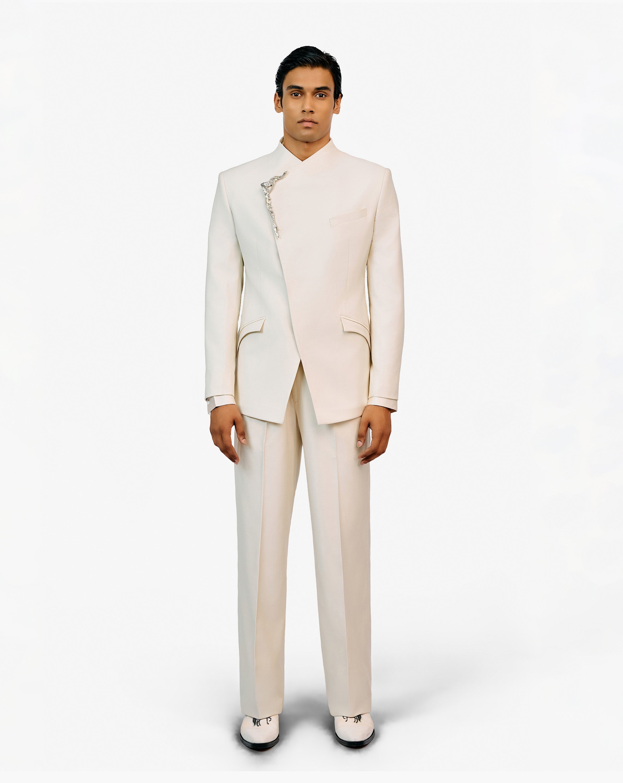 Model wearing a white embroidered sherwani set by Gaurav Gupta